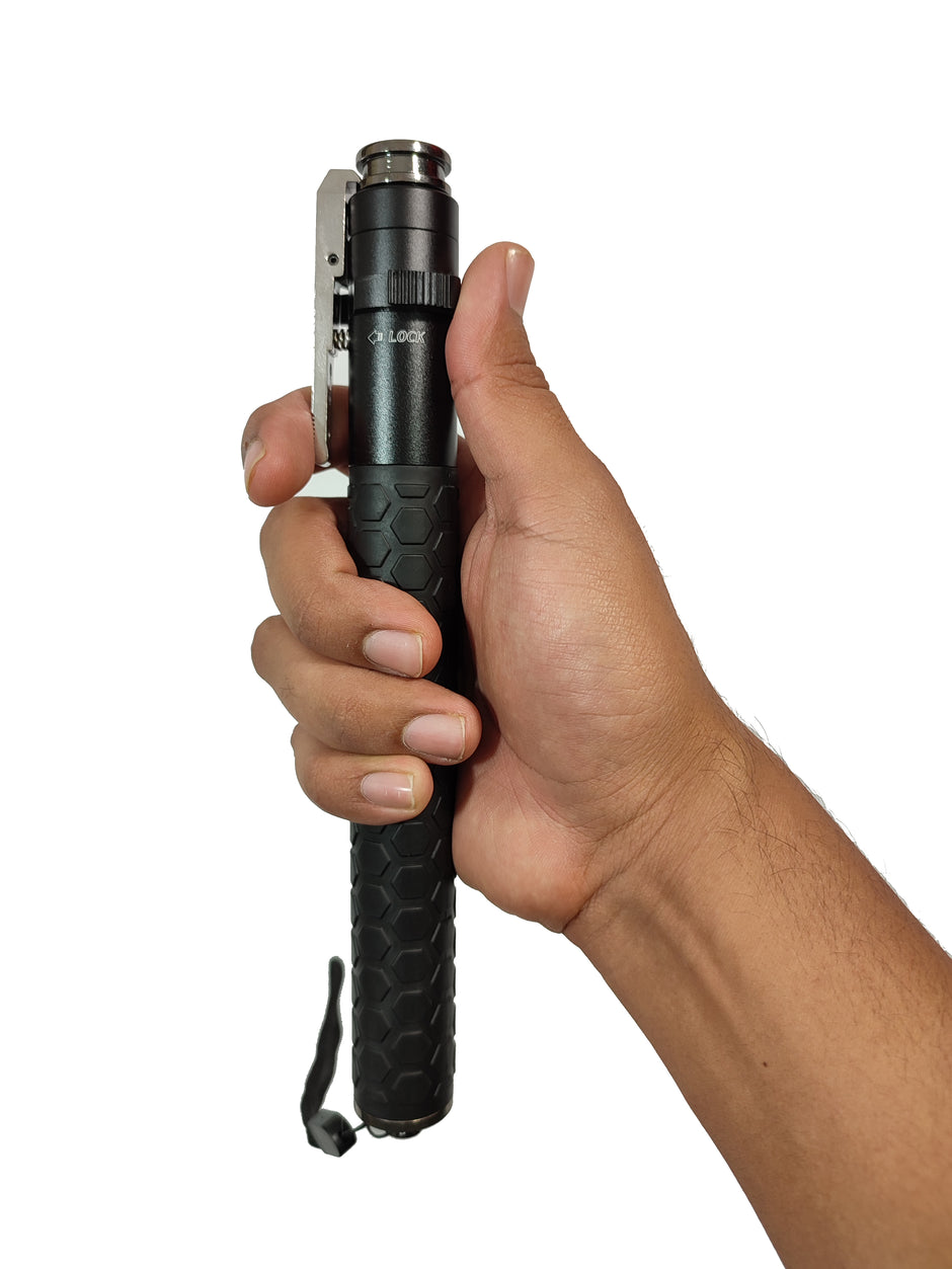 Bastón retráctil automático de mango anti derrapante con formas de hexágonos seguro para evitar aperturas y botón de apertura automático con ropa y cristales en la parte inferior guardado exhibido siendo sostenido por una mano